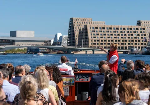Guide narrating the Copenhagen Canal Cruise route near the Little Mermaid statue