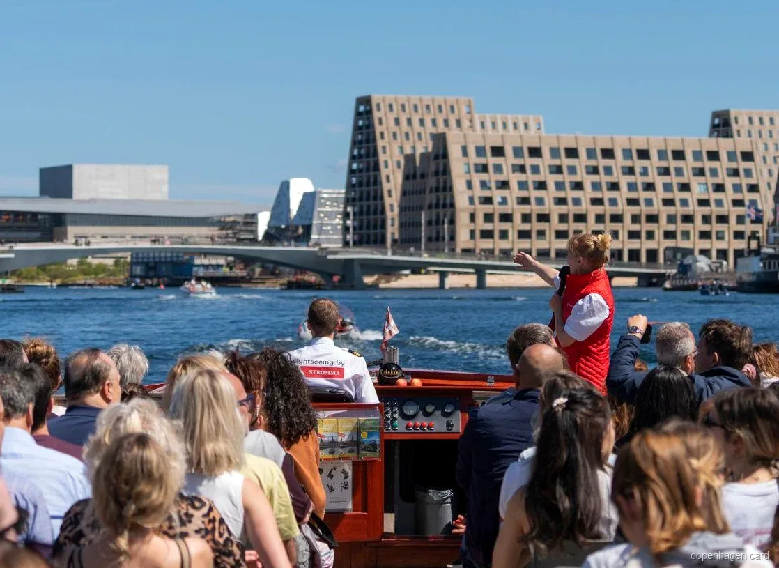 Guide commentant le trajet de la croisière sur les canaux de Copenhague près de la statue de la Petite Sirène