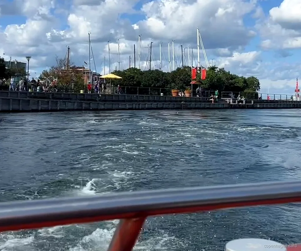 Łódź rejsu kanałami po Kopenhadze odpływająca z Ved Stranden obok historycznej zabudowy nabrzeża